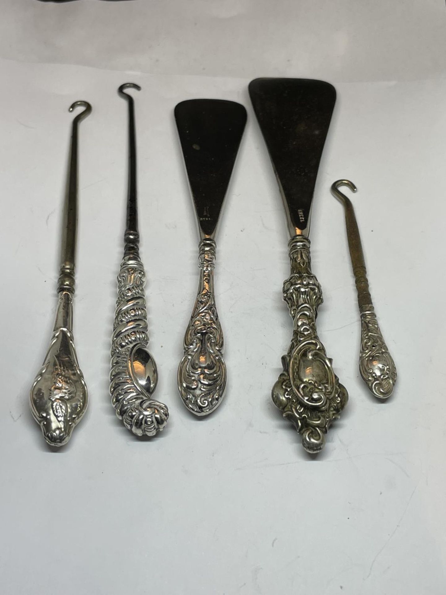 FIVE HALLMARKED SILVER HANDLED ITEMS TO INCLUDE BUTTON HOOKS AND SHOE HORNS