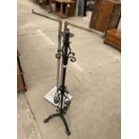 A WROUGH IRON STANDARD LAMP AND A CHROME ADJUSTABLE CLOTHES RACK
