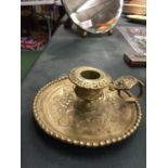 A BRASS EMBOSSED CANDLESTICK WITH HANDLE