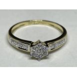 A 9 CARAT GOLD RING WITH CLEAR STONES IN A STAR DESIGN AND ON THE SHOULDERS SIZE J