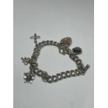 A SILVER CHARM BRACELET WITH A HEART PADLOCK AND FIVE CHARMS