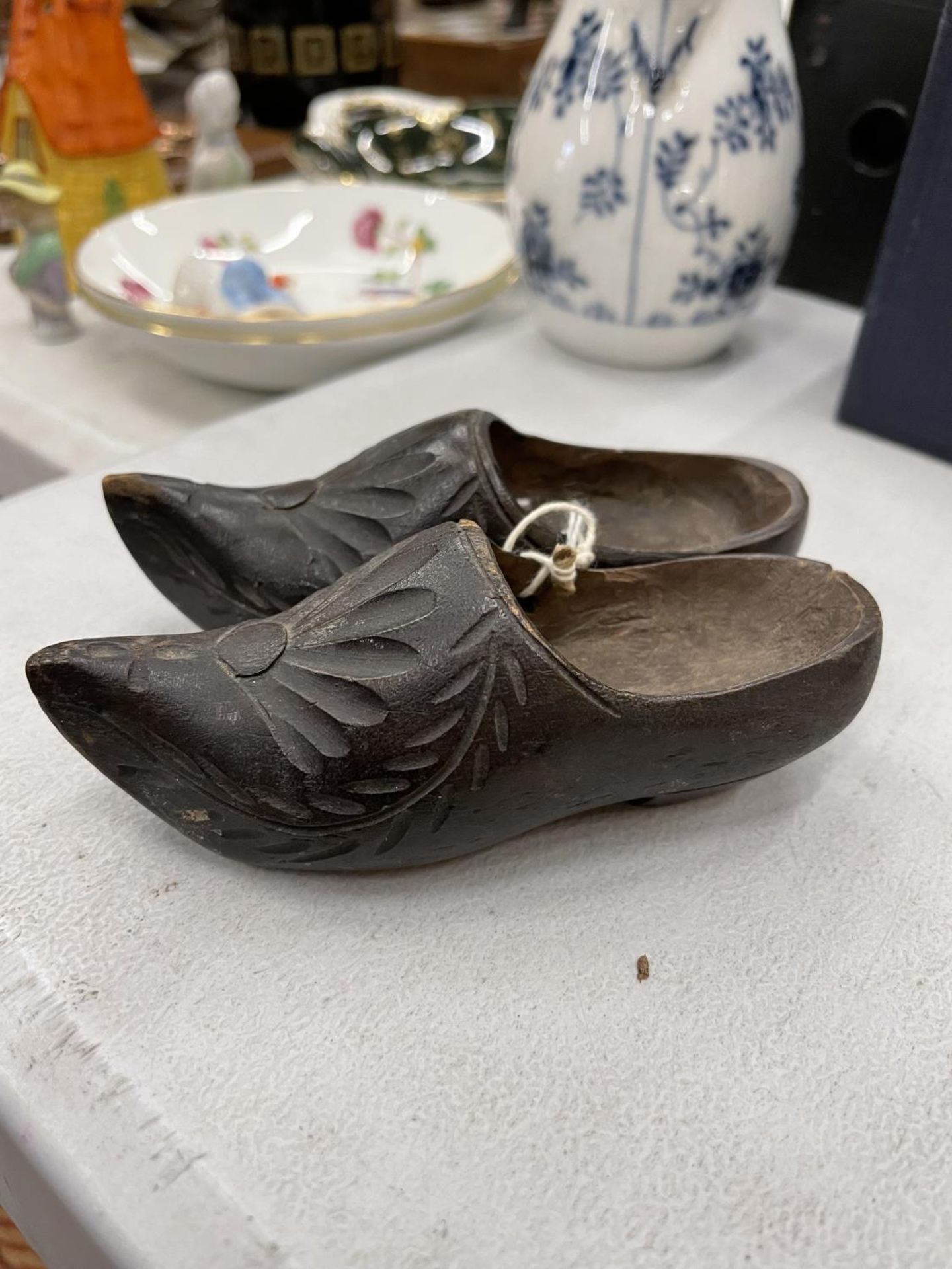 A PAIR OF MINIATURE WOODEN CLOGS WITH CARVED FRONTS