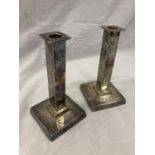 A PAIR OF SILVER PLATE ARTS AND CRAFTS STYLE CANDLESTICKS