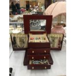 A WOODEN JEWELLERY CHEST WITH A MIRRORED LID AND THREE DRAWERS TO INCLUDE A QUANTITY OF COSTUME