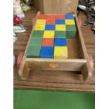 A VINTAGE CHILD'S WOODEN PULL ALONG CART CONTAINING COLOURED WOODEN BRICKS