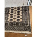 A BLACK AND FAWN FRINGED CARPET