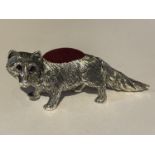 A SILVER MINIATURE PIN CUSHION IN THE FORM OF A FOX WITH RED STONE EYES