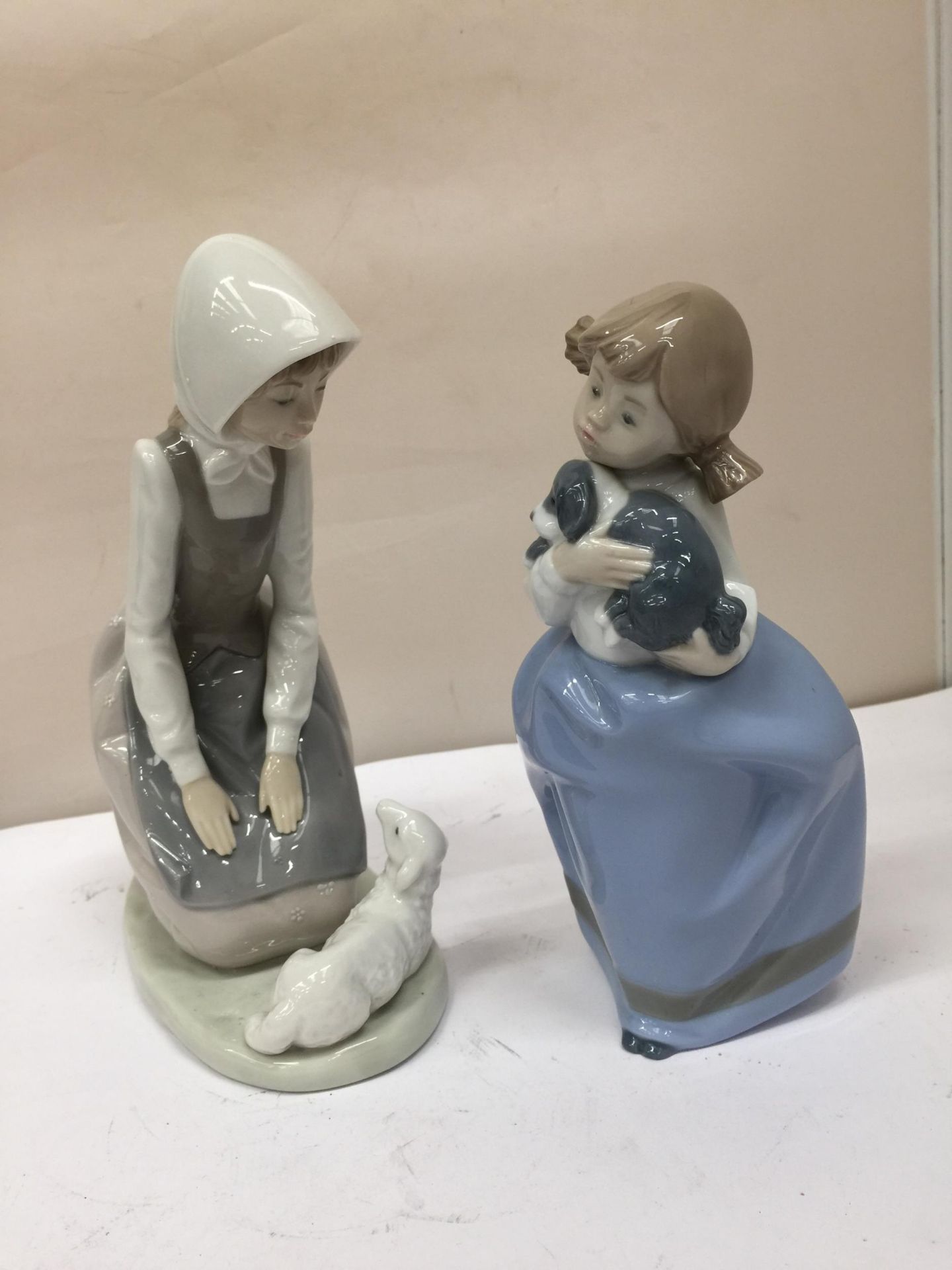 TWO NAO FIGURINES TO INCLUDE A GIRL AND A DOG AND A GIRL AND A LAMB