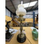 A BRASS LAMP WITH CHERUBS, GLASS FUNNEL AND DECORATIVE GLASS SHADE