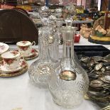 FOUR DECANTERS, TWO LEAD CRYSTAL, WITH COLLARS, ONE OF WHICH IS SILVER