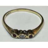 A 9 CARAT GOLD RING WITH A CENTRE DIAMOND AND AN AMETHYST EACH SIDE SIZE T