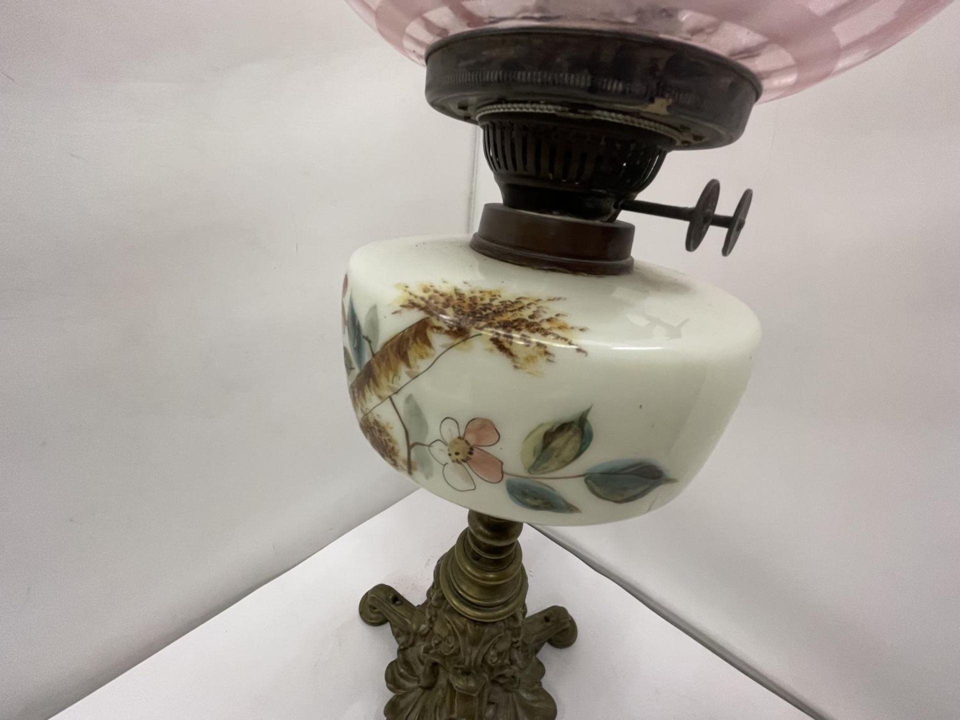 A BRASS OIL LAMP WITH DECORATIVE RESRVOIR, GLASS FUNNEL AND CRANBERRY GLASS SHADE - Image 4 of 5