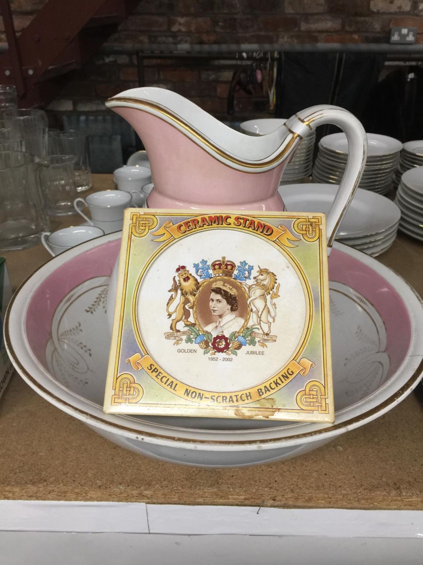 A LARGE WASHBOWL AND JUG - BOWL A/F PLUS A CERAMIC STAND COMMEMORATING THE QUEEN'S GOLDEN JUBILEE
