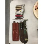 A COLLECTION OF ITEMS INCLUDING KNIVES IN SHEATHS, PEN KNIVES, BOTTLE OPENER, ETC
