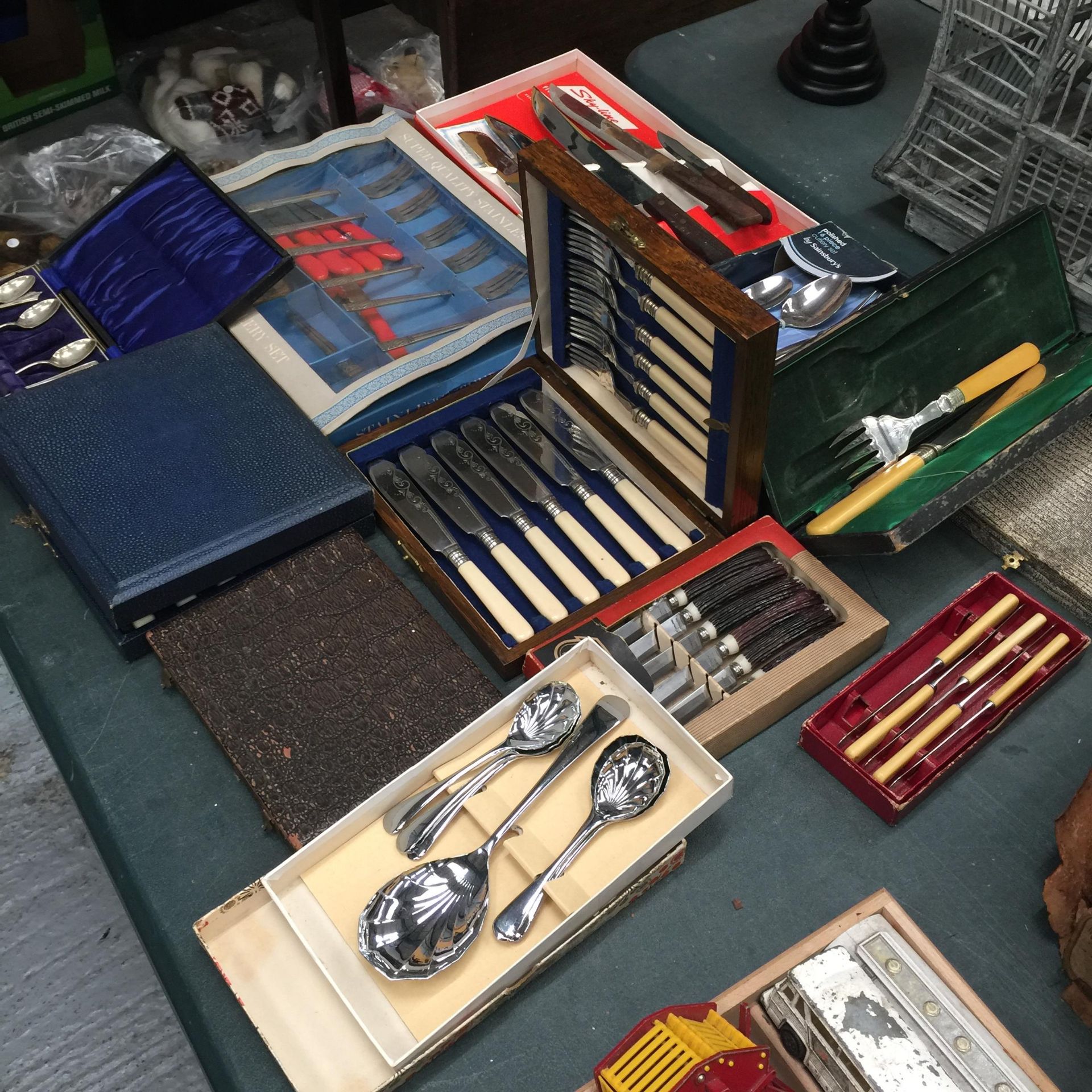 TWELVE BOXED SETS OF FLATWARE TO INCLUDE SPOONS, KNIVES, FORKS, SERVING SET, ETC