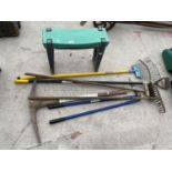 AN ASSORTMENT OF GARDEN TOOLS TO INCLUDE A PICK AXE AND RAKES ETC