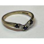 A 9 CARAT GOLD WISHBONE RING WITH THREE SAPPHIRES AND TWO CLEAR STONES SIZE L/M