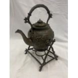 AN ORNATE METAL SPIRIT KETTLE AND STAND
