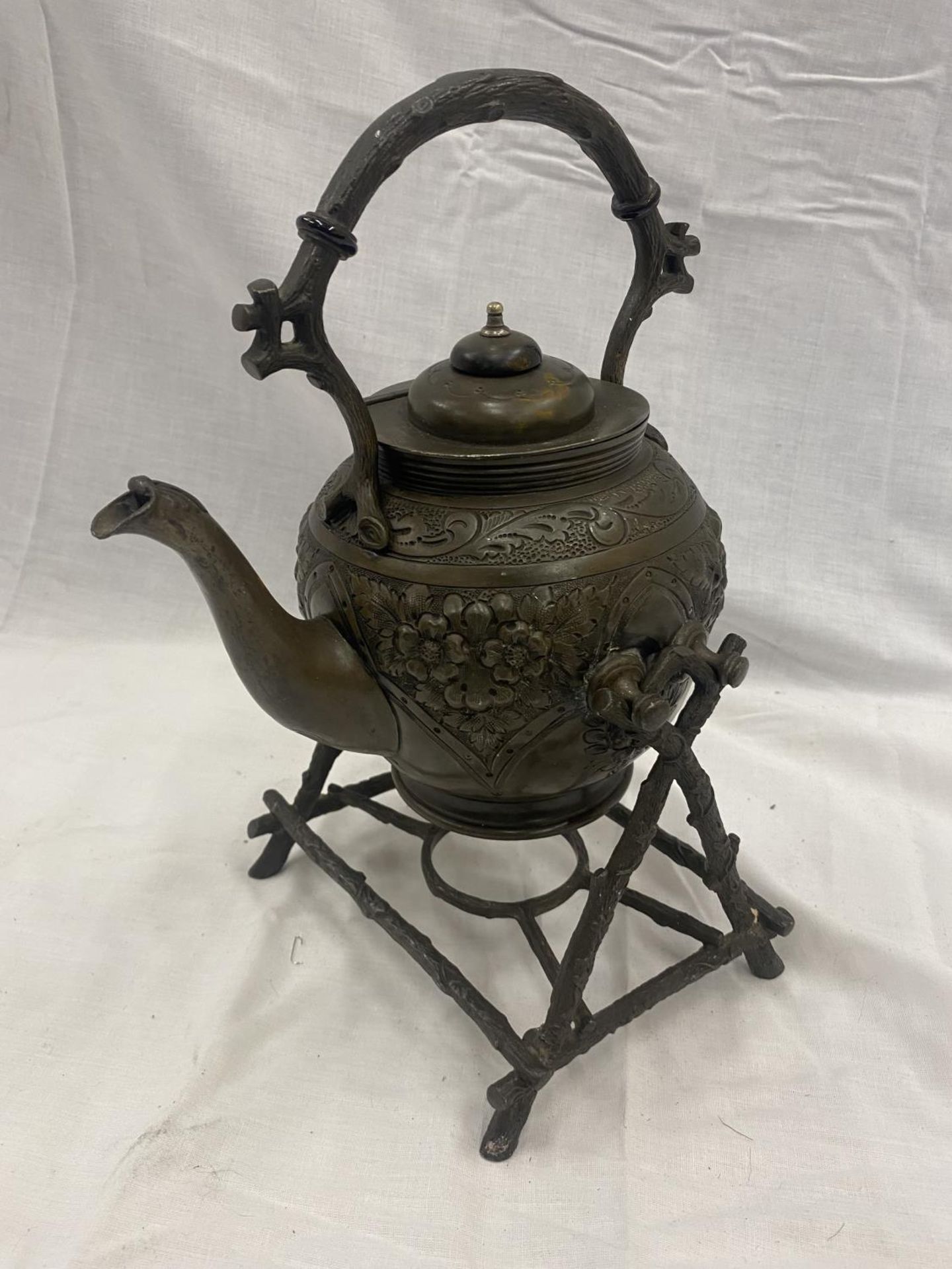 AN ORNATE METAL SPIRIT KETTLE AND STAND