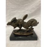 A SIGNED BRONZE OF HARES RUNNING ON A MARBLE PLINTH HEIGHT 12CM, LENGTH 15CM