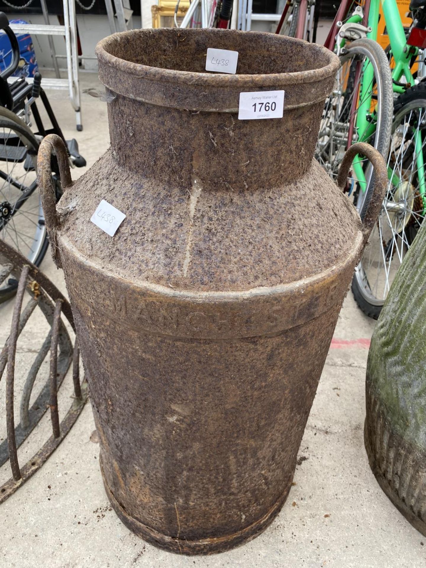 A VINTAGE CAST IRON MILK CHURN BEARING THE NAME 'MANCHESTER'