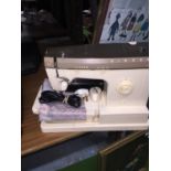 A CASED SINGER SEWING MACHINE WITH INSTRUCTIONS