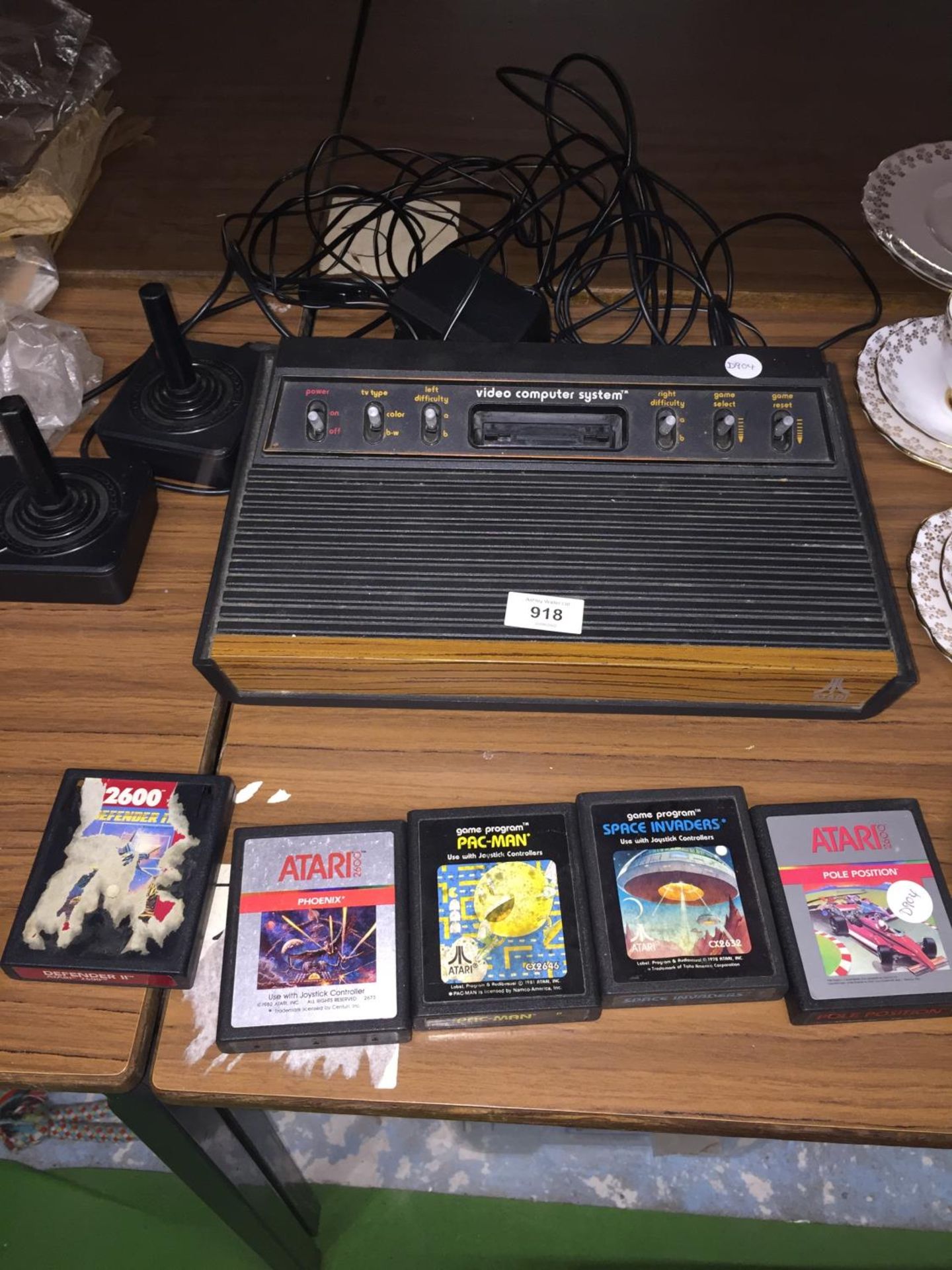 AN ATARI VIDEO COMPUTER SYSTEM WITH TWO JOYSTICKS PLUS FIVE GAMES TO INCLUDE PAC-MAN, SPACE