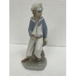 A LLADRO FIGURE OF A BOY WITH A SAILING BOAT