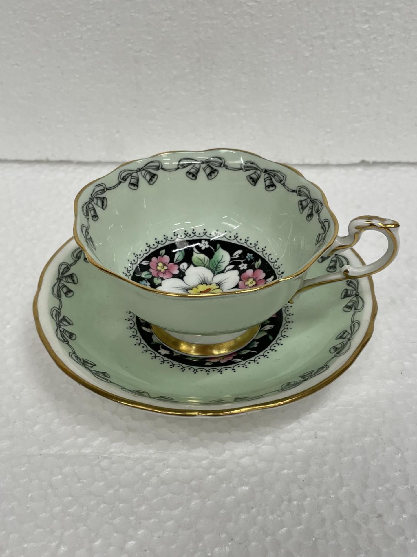 A PARAGON BY THE APPOINTMENT TO HM THE QUEEN AND HM QUEEN MARY CABINET CUP AND SAUCER IN GREEN
