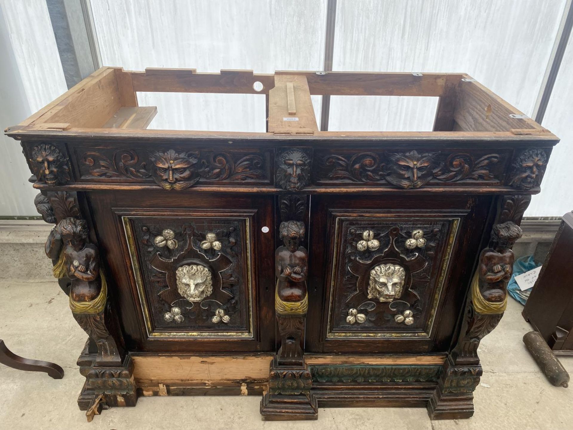 A VICTORIAN OAK HEAVILY CARVED BOOKCASE BASE WITH APPLIED CARVINGS OF ROBED LADIES AND LION MASKS,