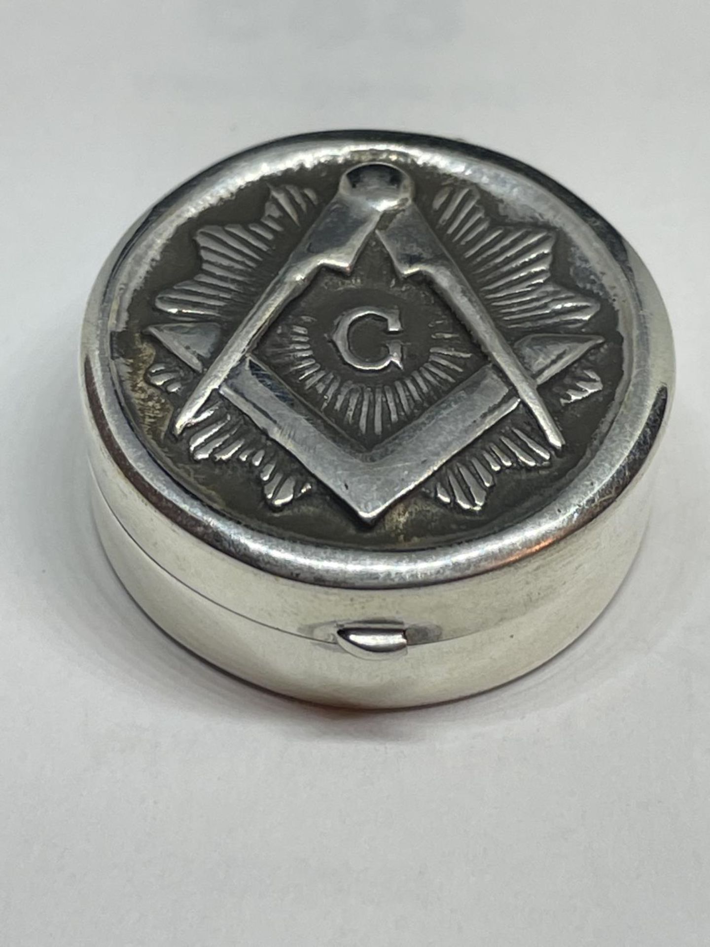 A MARKED SILVER PILL BOX WITH A MASONIC DESIGN