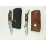 TWO FOLDING KNIVES AND SCABBARDS 7.5 CM AND 8 CM BLADES