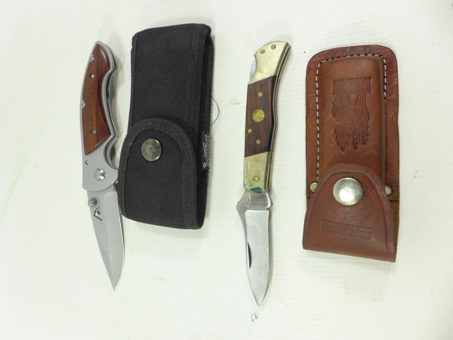 TWO FOLDING KNIVES AND SCABBARDS 7.5 CM AND 8 CM BLADES
