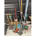 A LARGE ASSORTMENT OF GARDEN TOOLS TO INCLUDE SHOVELS, FORKS AND RAKES ETC