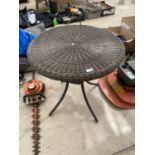 A WICKER TOPPED METAL BISTRO TABLE