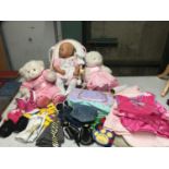 A QUANTITY OF CHILDREN'S AND DOLLS CLOTHES PLUS TEDDIES AND A DOLL ON A CHAIR