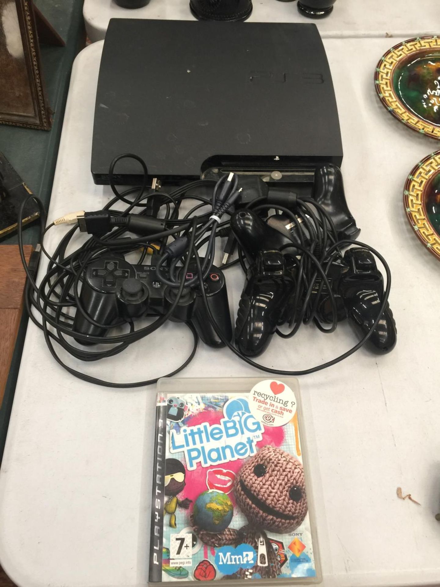 A PLAYSTATION 3 WITH THREE CONTROLLERS AND LITTLE BIG PLANET GAME