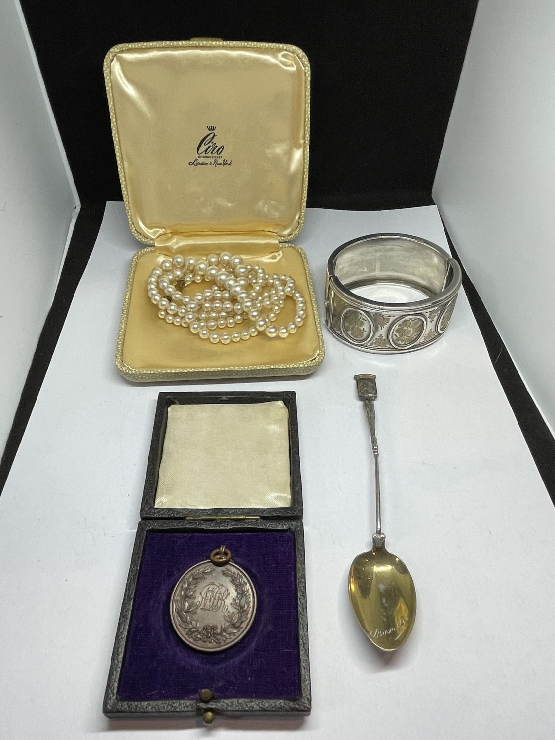 FOUR ITEMS TO INCLUDE A BOXED SET OF CIRO PEARLS, A POSSIBLY SILVER BANGLE, A SPOON AND A BOXED