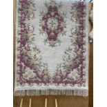 A CREAM AND PINK PATTERNED FRINGED RUG