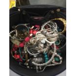A VANITY CASE CONTAINING A QUANTITY OF COSTUME JEWELLERY TO INCLUDE NECKLACES, BANGLES, BRACELETS,