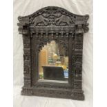 A HEAVILY CARVED EBONY ASIAN STYLE MIRROR WITH ELEPHANT DETAIL 52CM X 79CM