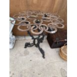 A DECORATIVE CAST IRON TABLE BASE WITH A HORSE SHOE TABLE TOP