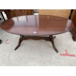 AN OVAL MAHOGANY AND CROSSBANDED COFFEE TABLE ON TWIN-COLUMN BASE