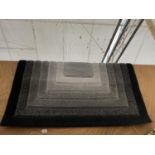 A MODERN BLACK AND GREY RUG