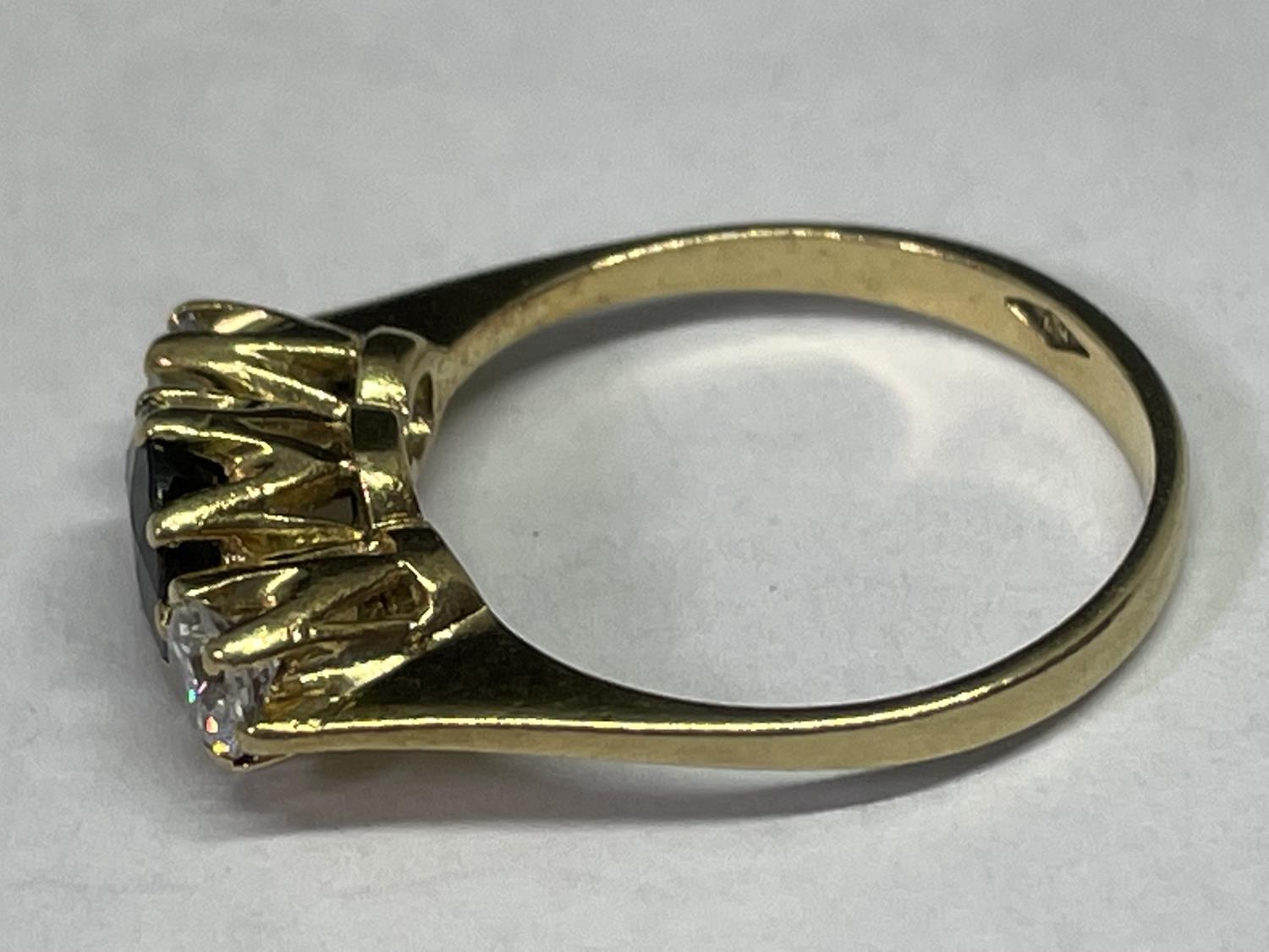 A TESTED TO 9 CARAT GOLD RING WITH CENTRE SAPPHIRE AND A CLEAR STONE EACH SIDE - Image 2 of 3