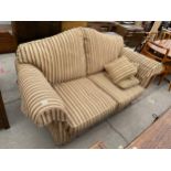 A VICTORIAN STYLE STRIPED TWO SEATER SETTEE ON TURNED FRONT LEGS WITH BRASS CASTERS
