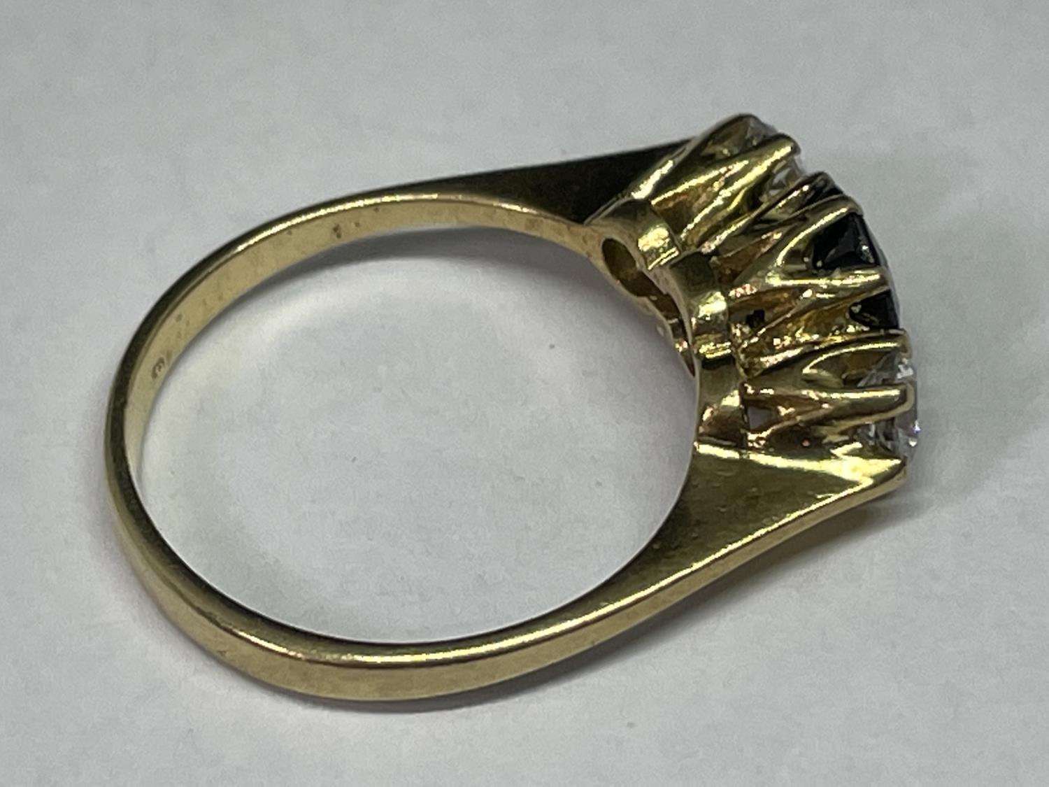 A TESTED TO 9 CARAT GOLD RING WITH CENTRE SAPPHIRE AND A CLEAR STONE EACH SIDE - Image 3 of 3