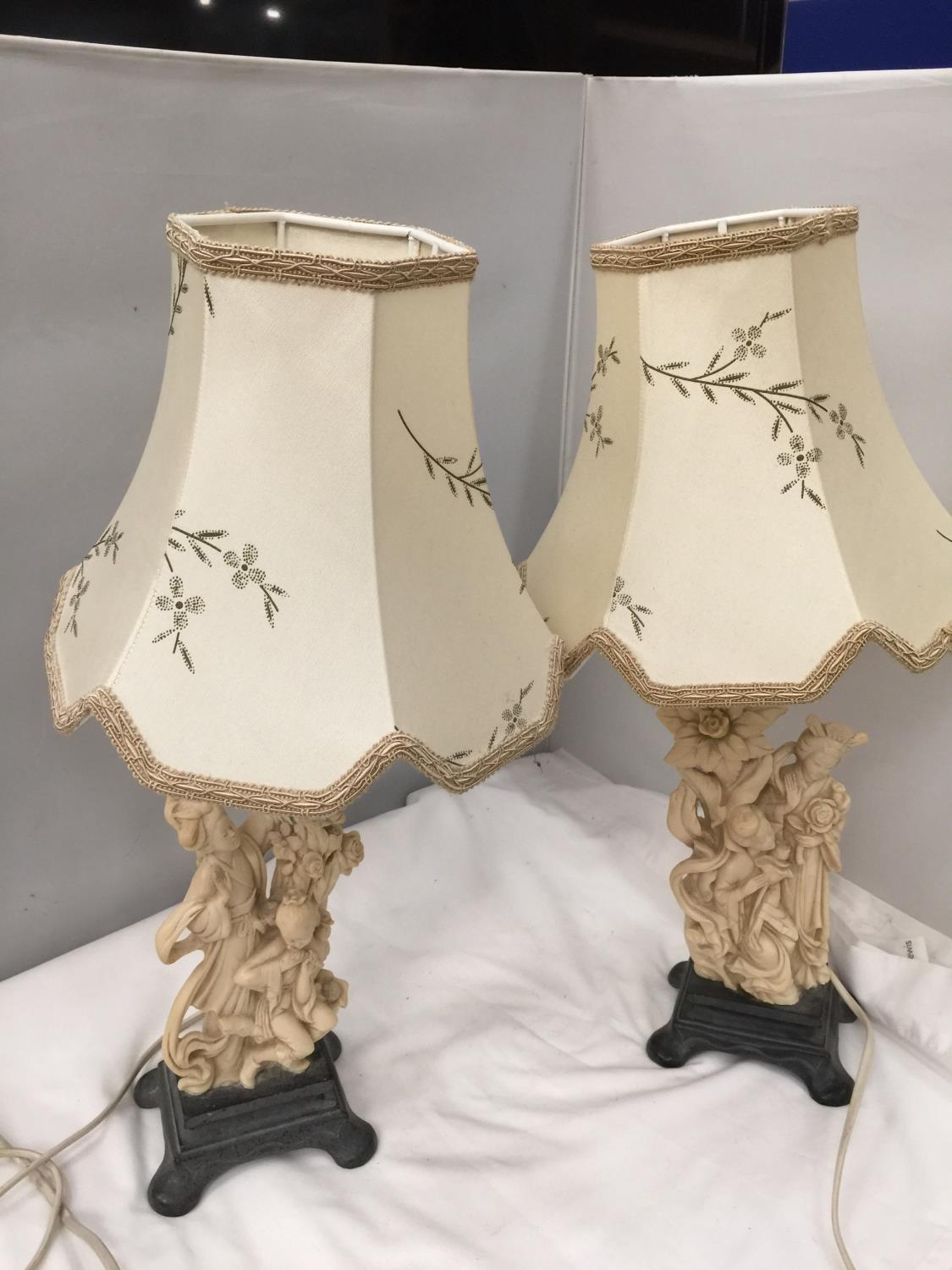 A PAIR OF CARVED ORIENTAL STYLE TABLE LAMPS DEPICTING LADIES AND FLOWERS