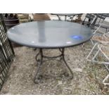 A DECORATIVE WROUGHT IRON BASED ROUND GARDEN PATIO TABLE WITH GRANITE TOP