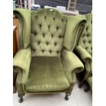 A MODERN GREEN WINGED BUTTON-BACK CHAIR ON CABRIOLE LEGS